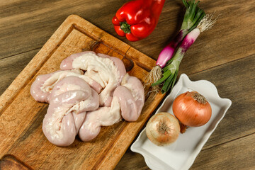 Cow bowels presented on a wooden board with ingredients, ready to grill