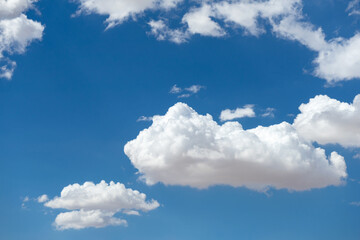 Obraz na płótnie Canvas Puffy cumulus clouds floating in the blue sky