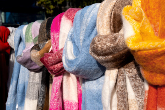 Various fluffy winter scarves in a row