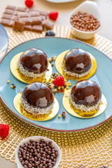 cupcake with chocolate cream. Chocolate cake with raspberry set on a blue plate and chocolate decor on a beige table.Berry dessert.Delicate airy cake souffle.Appetizing cupcakes and pastries.Choux