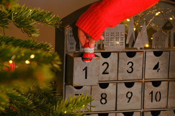 advent calendar. Chocolate santa claus in hand on christmas advent calendar background.child hand...