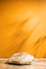 Podium texture stone for the presentation of products on a yellow background. still life for layout. Copy space and shadows.