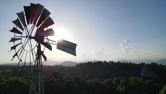 imagem a&eacute;rea de drone de um moinho de vento no sol.