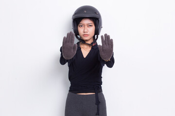 beautiful asian woman with a motorcycle helmet open hand doing stop sign with serious expression...