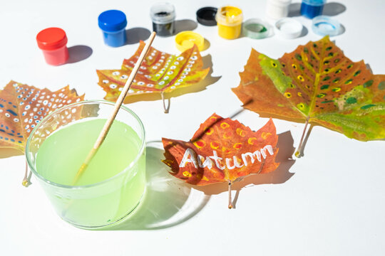 Painted fall leaves on a white background. Child creativity and zero waste concept.