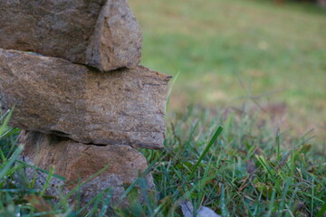 stacked rock column monument in an open grass field within a farm on a clear calm peaceful day on a hill in the country