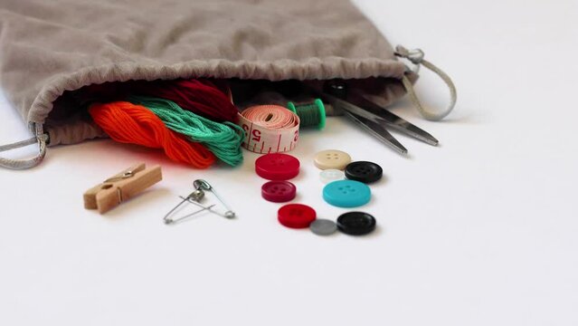 Sliding in front of sewing supplies pouring out of gray fabric bag
