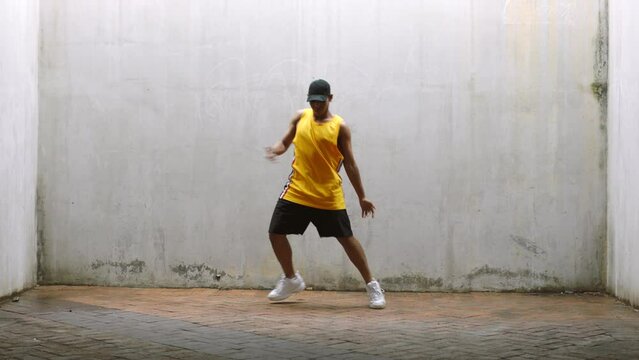 Hip hop dancer man dancing to music with energy in grunge aesthetic or youth wellness lifestyle with mockup. Cool, healthy and fitness gen z person dancing with body and white wall background mock up