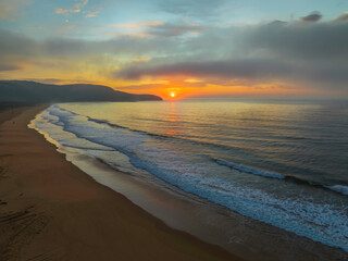 Fototapeta Peaceful sunrise over the ocean with small waves and clouds obraz
