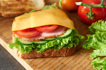 Sandwich with ham, vegetables and cheese slices. Photo wallpaper of delicious food.