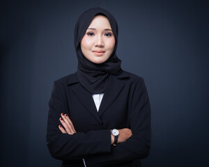 Portrait of an attractive Muslim woman wearing business attire and hijab with a corporate pose isolated on grey background. For image cut-out for technology, business or finance.