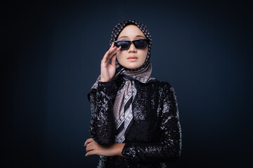 Portrait of a beautiful female model wearing hijab, a lifestyle apparel for Muslim women isolated on grey background. Idul Fitri and hijab fashion concept.