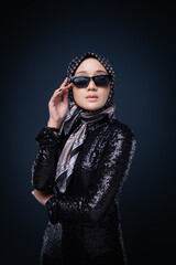 Portrait of a beautiful female model wearing hijab, a lifestyle apparel for Muslim women isolated on grey background. Idul Fitri and hijab fashion concept.