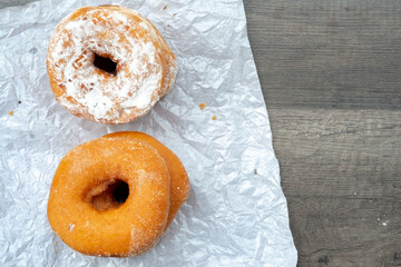 sweet donut buns on paper mat and wooden table background with space for text