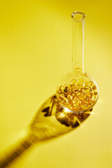 Omega-3 fatty acid capsules on a blue background in a flask. The concept of medicine and healthy living. Vertical photo.