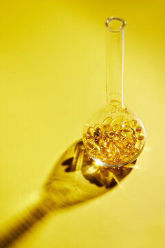 Omega-3 fatty acid capsules on a blue background in a flask. The concept of medicine and healthy living. Vertical photo.