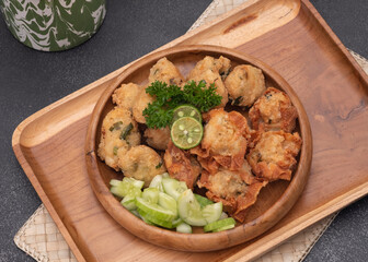 Delicious batagor or meatballs tofu is one of the popular indonesian traditional foods. Made from fish, tofu and peanut sauce. on wooden background. Top View, Close Up