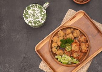 Fototapeta na wymiar Delicious batagor or meatballs tofu is one of the popular indonesian traditional foods. Made from fish, tofu and peanut sauce. on wooden background. Top View, Close Up