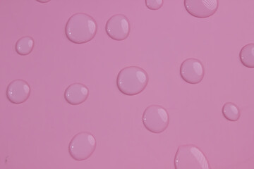Close up of dropped water on a pink background. Freshness, raindrop