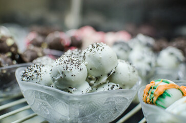 A collection of assorted chocolate candy balls in dishes on display