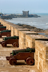 Fototapeta na wymiar The sun rises over a row of cannons at the former fortress at Essaouira in Morocco. The present city of Essaouira was built facing the Atlantic Ocean.