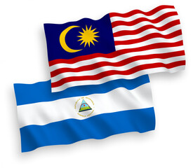 National vector fabric wave flags of Nicaragua and Malaysia isolated on white background. 1 to 2 proportion.