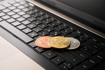 Bitcoin and laptop computer, close-up