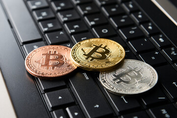 Bitcoin and laptop computer, close-up