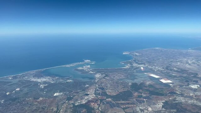Aerial view of the spanish city and bay of Cadiz  at 5000 metres high with a deep blue sky and daylight. taken from a jet cockpit.  4k