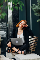 Beautiful woman working on laptop at outdoors cafe