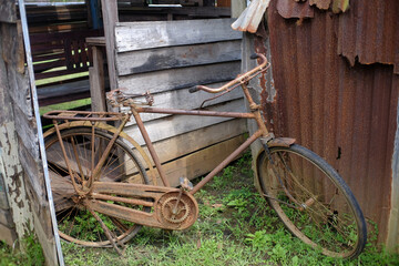 An old, very rusty bicycle was parked in the corner of an abandoned house.