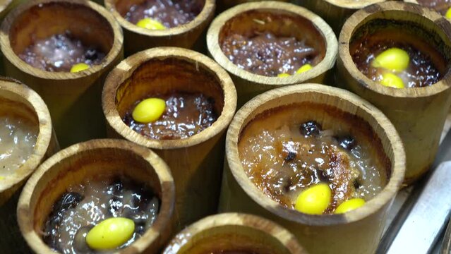 Khao lam baked sticky rice with beans and coconut milk in fresh bamboo container Thai style dessert