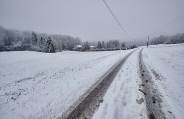 Route enneigée qui va en direction des petites maisons