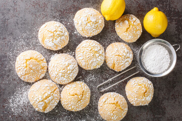 Festive homemade cracked lemon cookies with powdered sugar close-up on the table. horizontal top view from above
