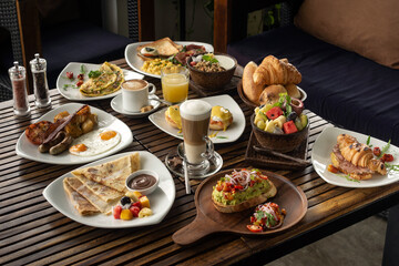 many mixed western breakfast food items on cafe table - 534120733