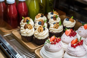 Mini Pavlova dessert on a candy bar, wedding buffet table. cakes decorated berries and fruits