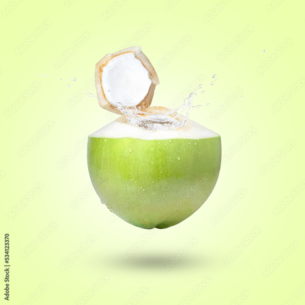 Poster young coconut with coconut water splash isolated on green background.