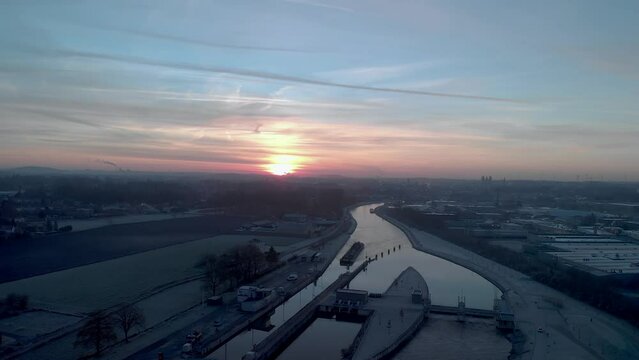 Drone shot dolly sideways of barges approching a sluice on the Scheldt river next Tournai in Belgium in the winter morning