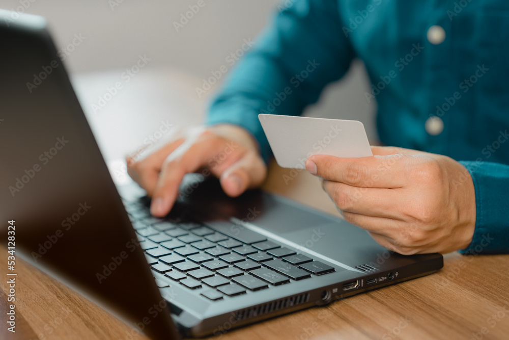 Poster man uses a laptop to register through a credit card to make online purchases. credit card safe onlin