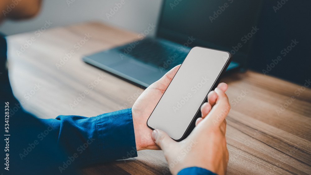 Poster Mockup image of a man holding and using smartphone with blank desktop screen while working and drinking coffee in cafe.