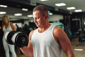 Fototapeta na wymiar Middle-aged fit muscular man training in a sports gym
