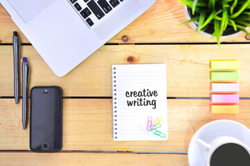 Concept of creative writing. Copy space. Creative writing written on notebook.