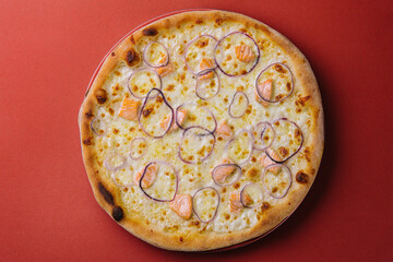 Pizza with salmon on red background
