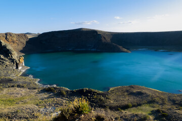 view of the blue lagoon from above showing a part of the crater of the inactive volcano filled with turquoise water