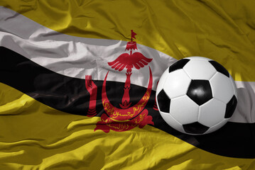Fototapeta premium vintage football ball on the waveing national flag of brunei background. 3D illustration