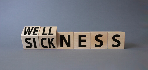 Wellness and Sickness symbol. Turned cubes with words sickness and wellness. Beautiful grey background. Business and wellness and sickness concept. Copy space