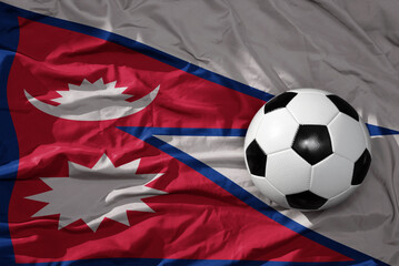 vintage football ball on the waveing national flag of nepal background. 3D illustration
