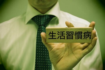 生活習慣病と書かれた積み木を持つ人物