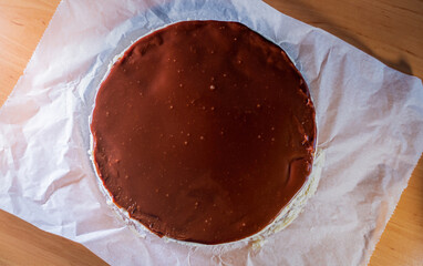 Top view of a chocolate cocoa cream on top of a round coconut cake
