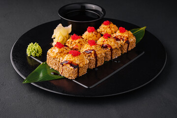 Traditional baked japanese sushi on black plate